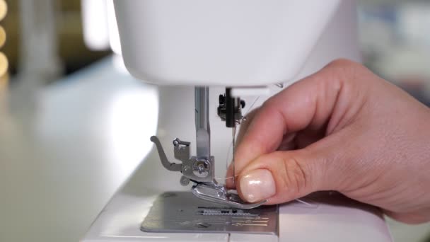 Mujer pone hilo en la aguja en la máquina de coser preparándose para trabajar, manos de cerca . — Vídeos de Stock