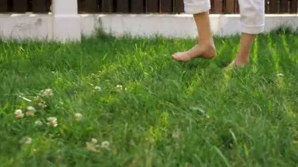 Magro mãe e pequeno menino pernas andar descalço no gramado verde — Vídeo de Stock