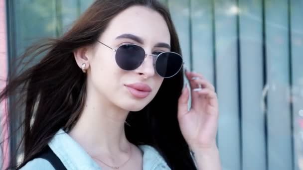 Ładna Brunetka z długimi włosami zabiera czarne okulary przeciwsłoneczne — Wideo stockowe
