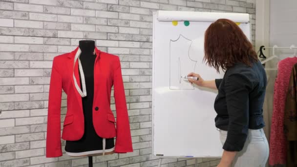 Dressmaker ritar ett mönster av jacka på Whiteboard i sömnad workshop. — Stockvideo