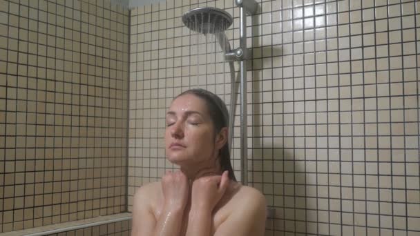 Brunett kvinna med långa hårstrån tar en dusch — Stockvideo