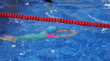 Gözlük mayo kap ve paletli çocuk kız havuzda yüzme eğitimi.