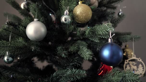 Árbol de Navidad artificial con guirnaldas brillantes en la oscuridad — Vídeos de Stock