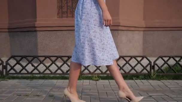 Slim european model in trendy blue dress walks along street — Stock Video