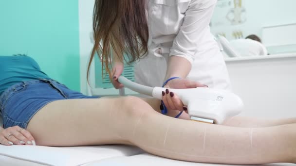 Terapeuta rende depilazione laser sulla gamba visitatore vista da vicino — Video Stock
