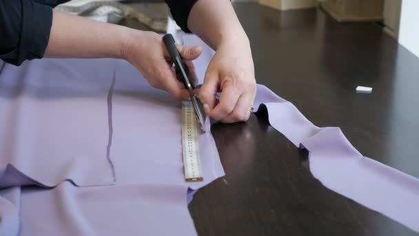 Tagli sartoriali stoffa utilizza forbici seguono segni di gesso del modello, mani primo piano . — Video Stock