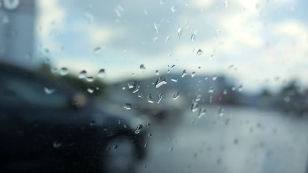 Primeras gotas de lluvia en la ventana del coche, vista en la carretera con los coches a través de ella . — Vídeos de Stock