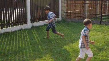 gülümseyen küçük çocuklar yeşil bahçesinde çim boyunca çalışan gülmek