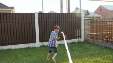 Şortlu çocuk su tabancası jetinden kaçar ve düşer.