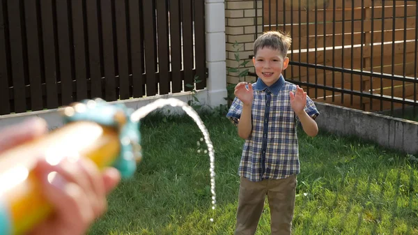 Cute uczniak cieszy krople płynące z wody pistolet Jet — Zdjęcie stockowe