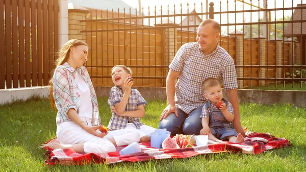 Niños pequeños felices disfrutan de picnic con la madre padre riendo — Foto de Stock