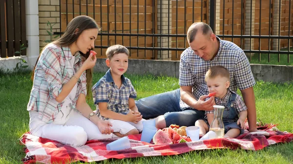 Madre con el pelo castaño se sienta con el padre guapo y los niños — Foto de Stock