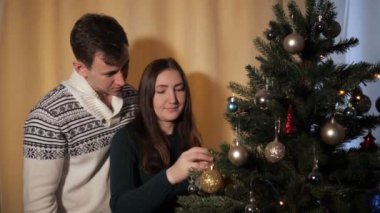 adam bayan arkasında duruyor noel ağacı dekorasyon yardımcı olur
