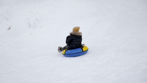 Ευτυχισμένη μαμά και γιος γλιστρούν από το χιόνι λόφο σε σωλήνες σε αργή κίνηση. — Αρχείο Βίντεο