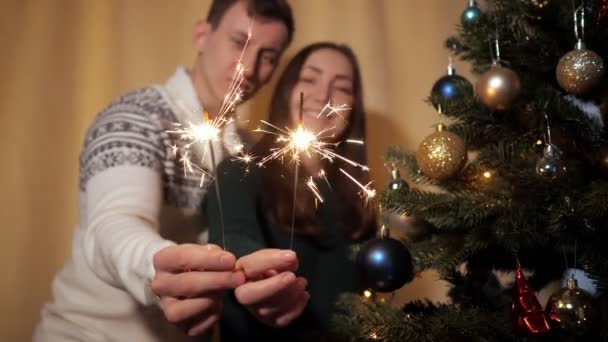 Lyckligt par i tröjor håll ljusa tomtebloss nära kameran — Stockvideo