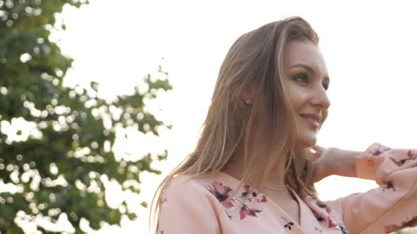 Mulher com cabelo liso solto no vestido rosa sorrisos e poses — Vídeo de Stock