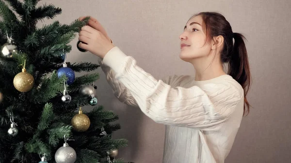 Счастливая юная леди с хвостиком украшает елку — стоковое фото