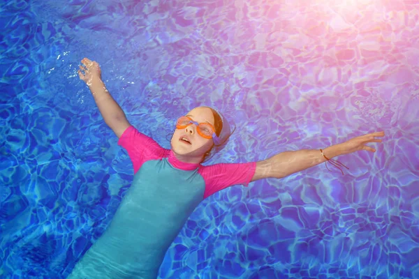 Portrait de fille calme se détendre dans l'eau bleue claire de piscine ensoleillée en plein air . — Photo