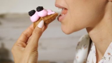 güzel kadın krem ve çilek closeup ile éclair yiyor