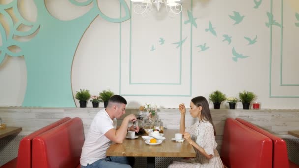 Encantadora familia pasa el tiempo comiendo pasteles en la confitería — Vídeos de Stock