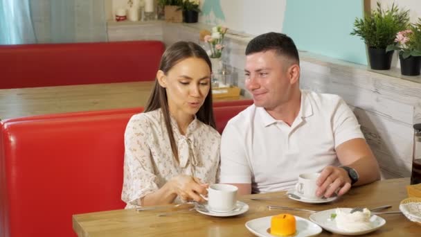 Lovely couple drinks tea having date in confectionery shop — Stock Video
