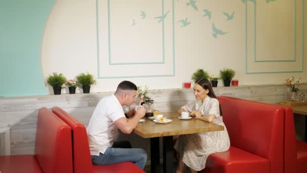 Lovely couple drinks tea having date in confectionery shop — Stock Video