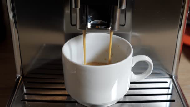 コーヒーは部屋の現代のコーヒーマシンからカップに注ぐ — ストック動画