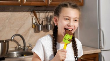 Genç kız çikolata ve gülümseyerek plastik spatula yalıyor.