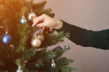 kadın elleri tutun ve noel ağacı üzerinde altın oyuncak topu asmak