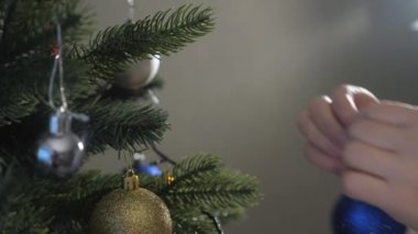 bayan noel süslemeleri tutar ve yapay ağaç koyar
