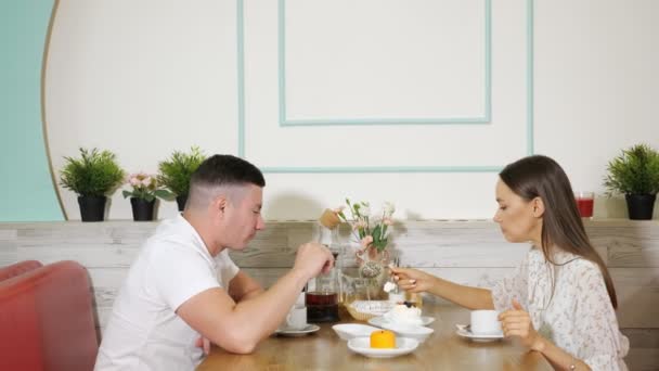 Krásný pár tráví čas pojídáním koláčů v cukrářské dílně — Stock video