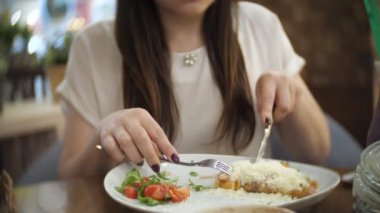 genç kız kafede jambon, peynir, yeşillik ve domates ile krep yiyor