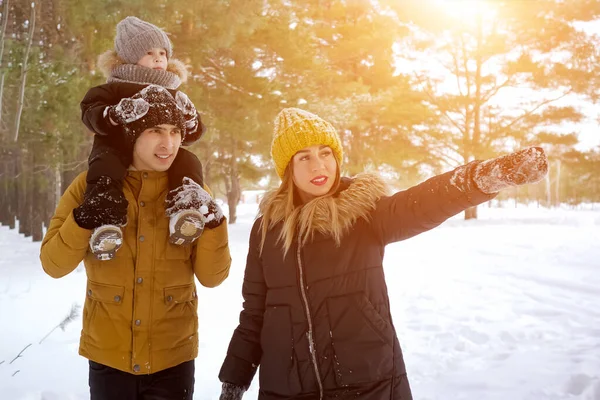 Familia, mamá, hijo y papá están caminando tigether en el parque de invierno . — Foto de Stock