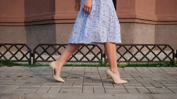 Pani w nogach sukienka w beżowy wysokie obcasy chodzić wzdłuż ulicy — Zdjęcie stockowe