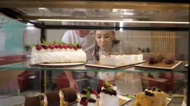 mutlu çift dükkan cam show durumda lezzetli kek seçer