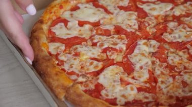 Kadın eli leziz, renkli pizza dilimleri ve yakın görüş alır.