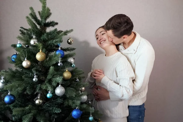 Homme se tient derrière dame aide à décorer arbre de Noël — Photo