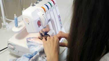 Overlok bez kenarlarında atölye atölyesinde dikiş terzisi, eller closeup.