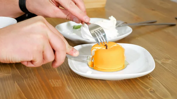 Jeune homme coupe gâteau en forme de pomme sur plaque blanche à la table — Photo