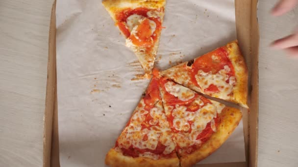 Casal leva deliciosas fatias de pizza coloridas da caixa de artesanato — Vídeo de Stock