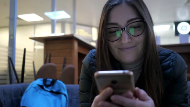 Mulher bate-papos com amigos usando smartphone e sorrisos — Vídeo de Stock