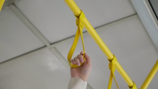 Mujer mano sostiene barandilla vendaje en tranvía de bajo ángulo tiro — Vídeo de stock