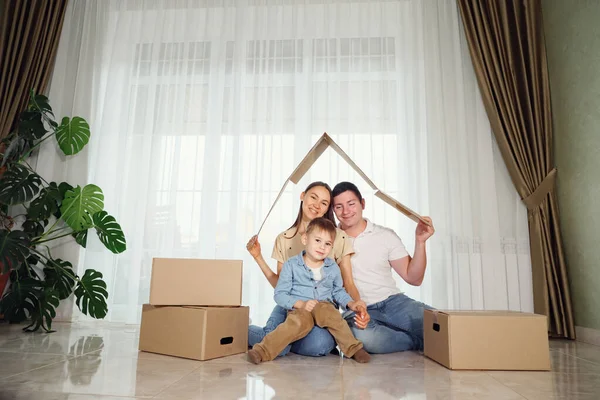 Mother father and child in new house with a roof at a home Stock Image