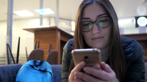 Mujer chats con amigos usando teléfono inteligente y sonrisas — Vídeo de stock