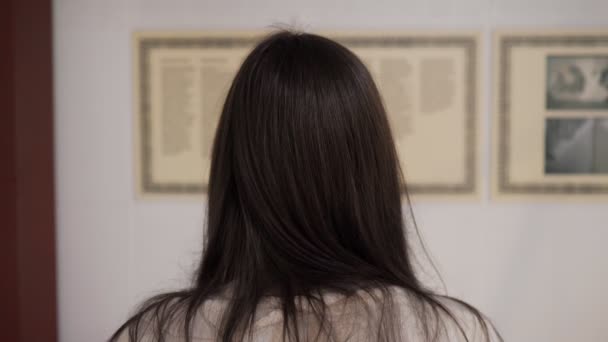 Lady stands in national art gallery and reads information — Stock Video