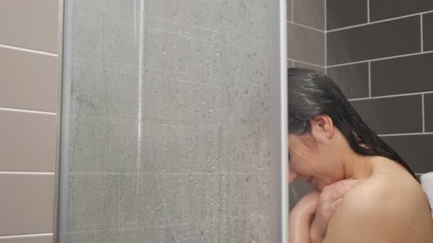Молодая женщина волосы стоит под душем — стоковое видео