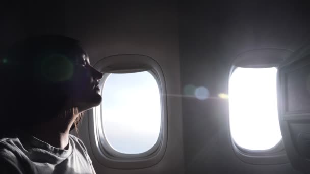 femme demi-visage silhouette contre avion de ligne fenêtres gros plan 
