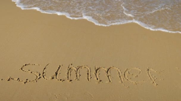 Mořská vlna vymazává slovo léto na písku. Zpomalený pohyb — Stock video