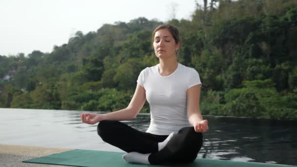 Yogi novizia donna seduta in posizione loto, torna in piscina — Video Stock