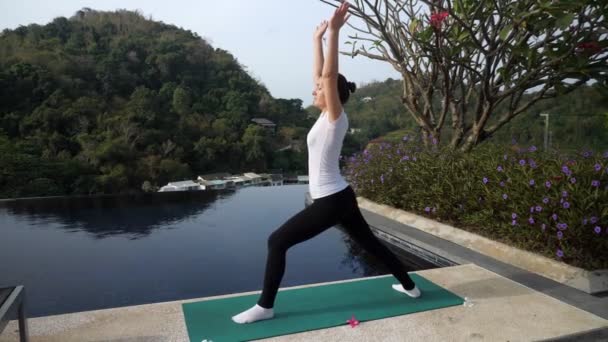 Femme dans un T-shirt blanc se tient dans une pose de guerrier — Video